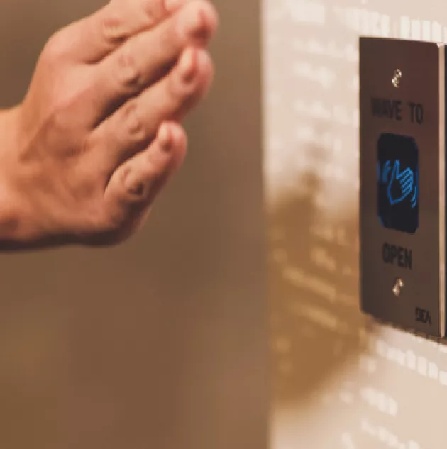 Hand waves in front of sensor to open door.